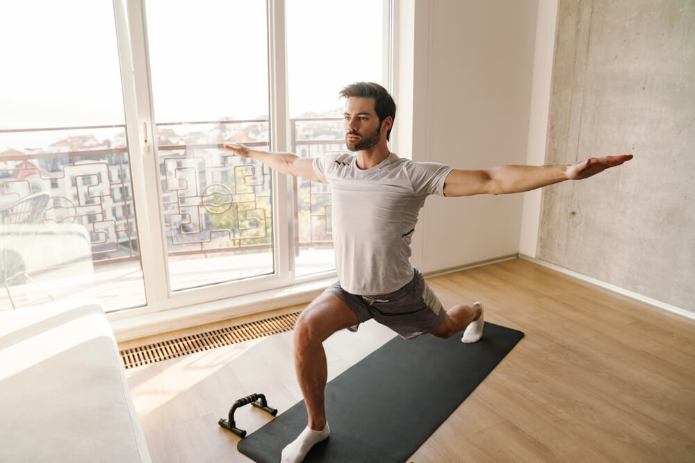 Man performing a lunge stretch to improve men’s mobility and longevity at home