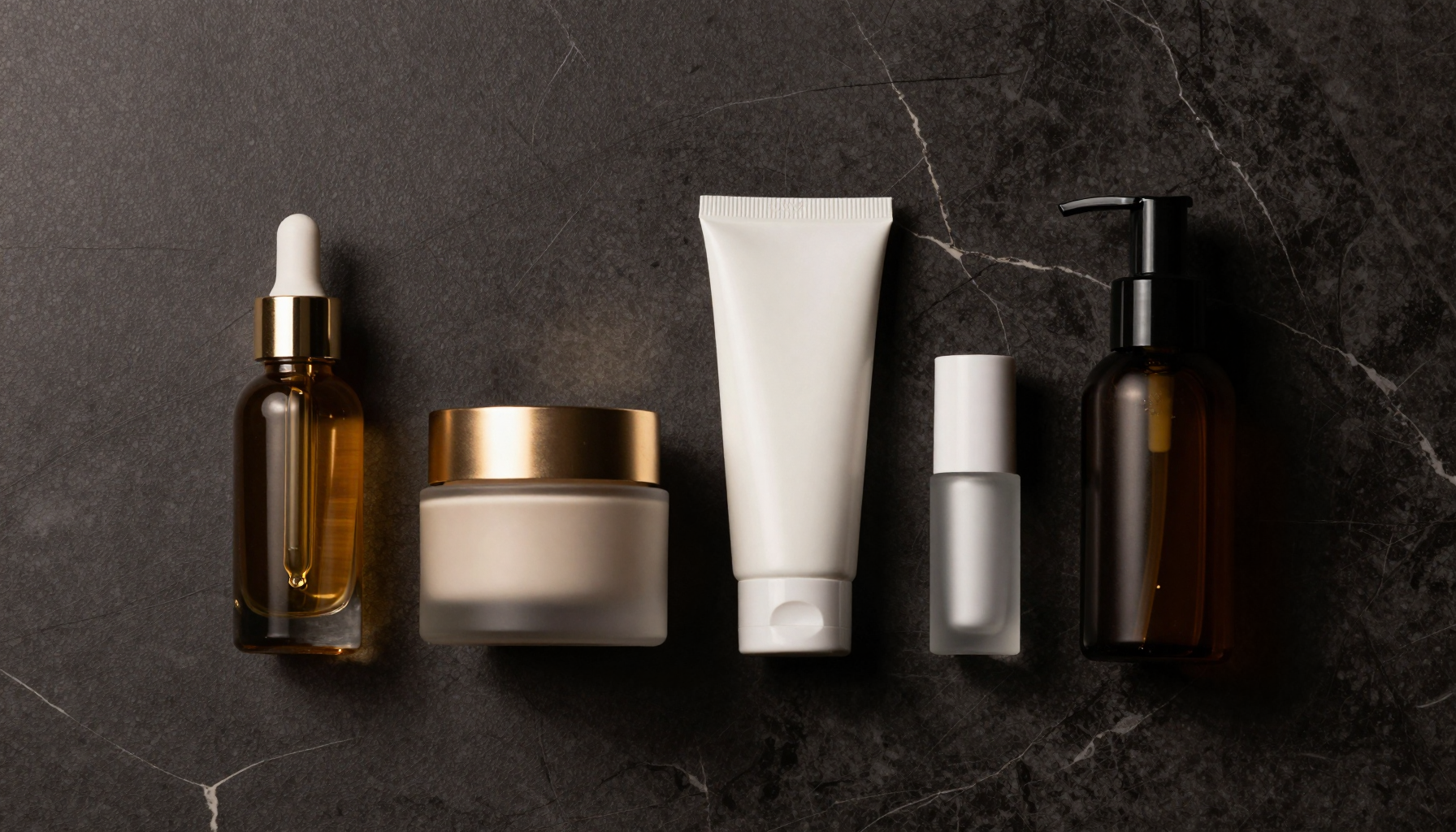 Luxury men's skincare products on a dark marble surface including serum, moisturizer and SPF, Belldiva