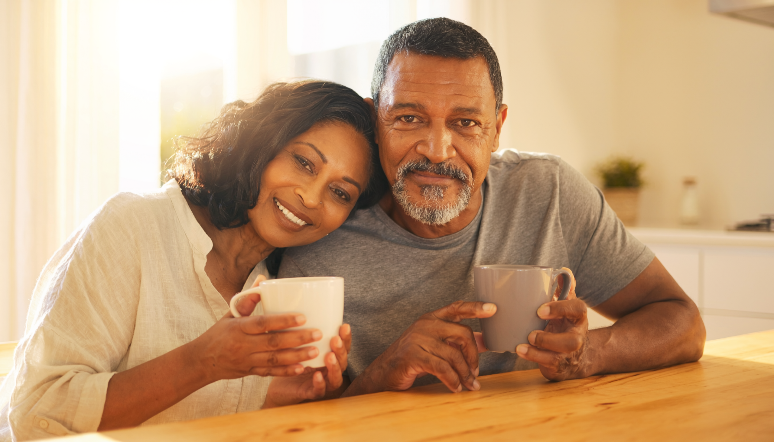 A warm intimate couple sharing morning coffee at home navigating menopause and andropause together