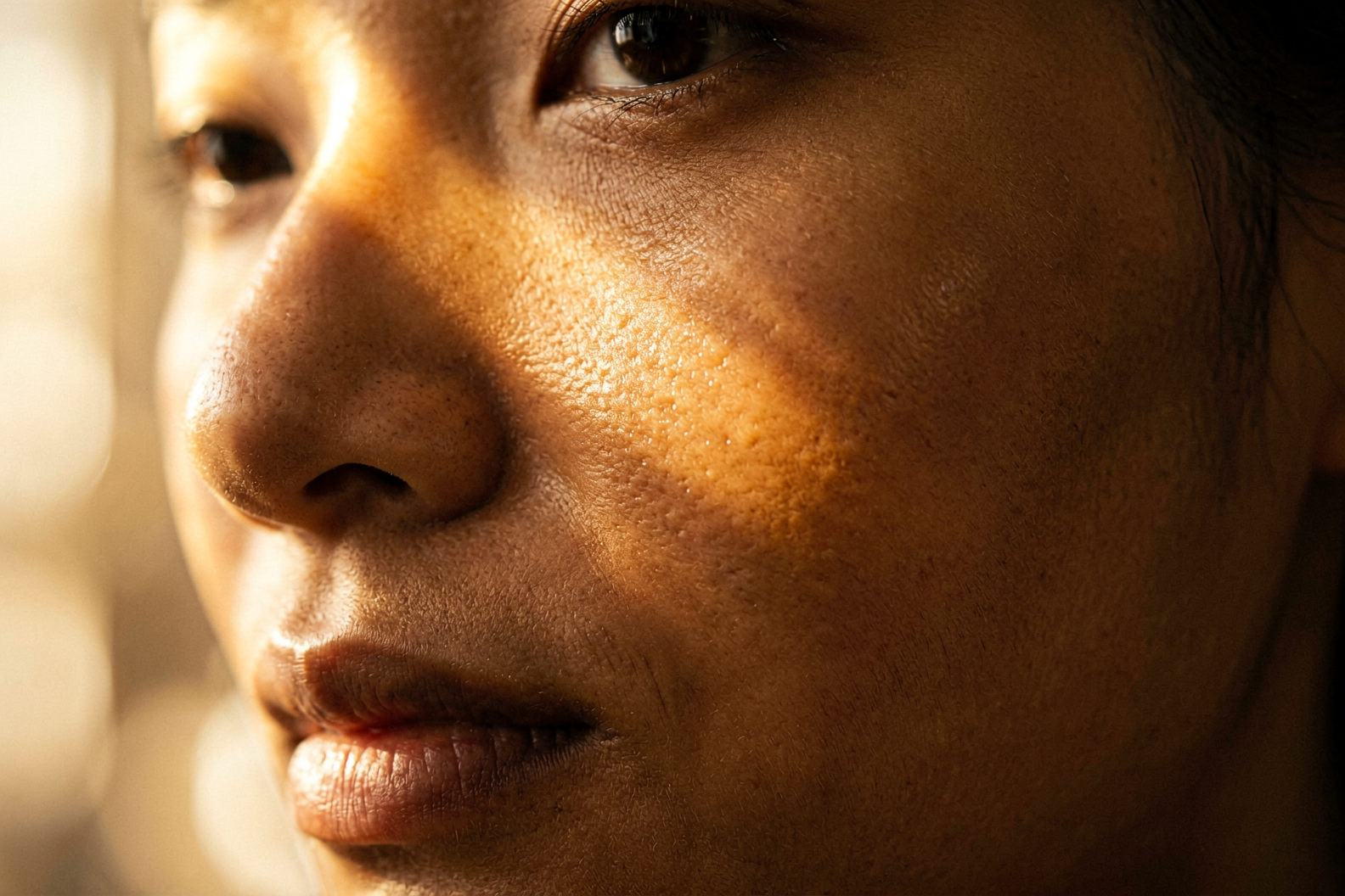 Close-up of rich brown skin texture illustrating melanin production and hyperpigmentation treatment biology, Belldiva skincare guide