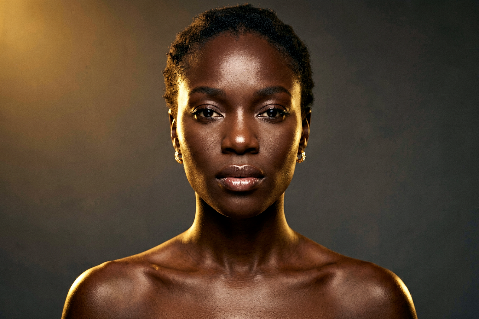 Radiant woman with deep brown melanin-rich skin representing skincare and hyperpigmentation treatment for diverse skin tones, Belldiva